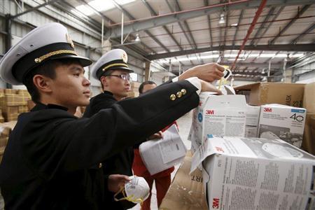 押収した米３Ｍ製品を模造した偽物マスクを調べる上海税関の係官。人の命より利益を追い求める中国ビジネスこそ“赤色警報”の対象だ＝２０１５年１２月９日、中国・上海市（ロイター）