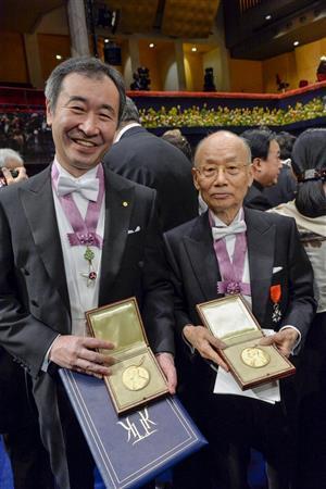 授与されたノーベル賞のメダルを披露する梶田隆章（たかあき）・東大宇宙線研究所長（左）と、大村智（さとし）・北里大特別栄誉教授＝２０１５年１２月１０日、スウェーデン・首都ストックホルム（ロイター）