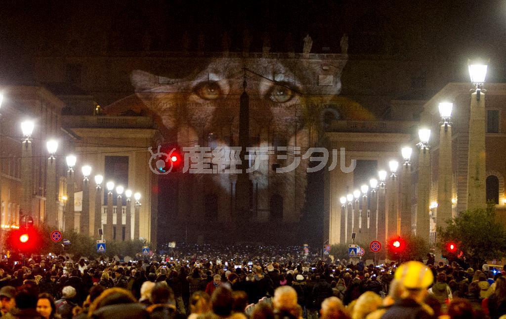サンピエトロ大聖堂の正面に移し出された動物や魚の映像を見る人々＝２０１５年１２月８日、バチカン（ＡＰ）