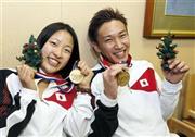 アラブ首長国連邦から帰国し、金メダルを手に笑顔の奥原希望（のぞみ、左）と桃田賢斗＝２０１５年１２月１４日午後、千葉県成田市の成田空港（共同）