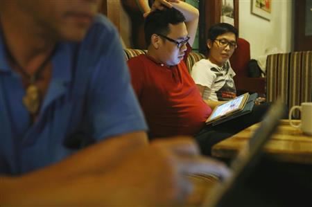 携帯端末を操作する男性ら。ベトナムは電子商取引が拡大中だ＝ハノイ（ＡＰ）