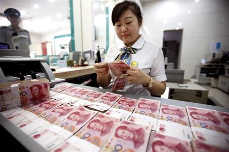 安徽省の淮北市にある銀行で、紙幣を数える行員。中国・人民元は国際通貨足りうるのか（ＡＰ）