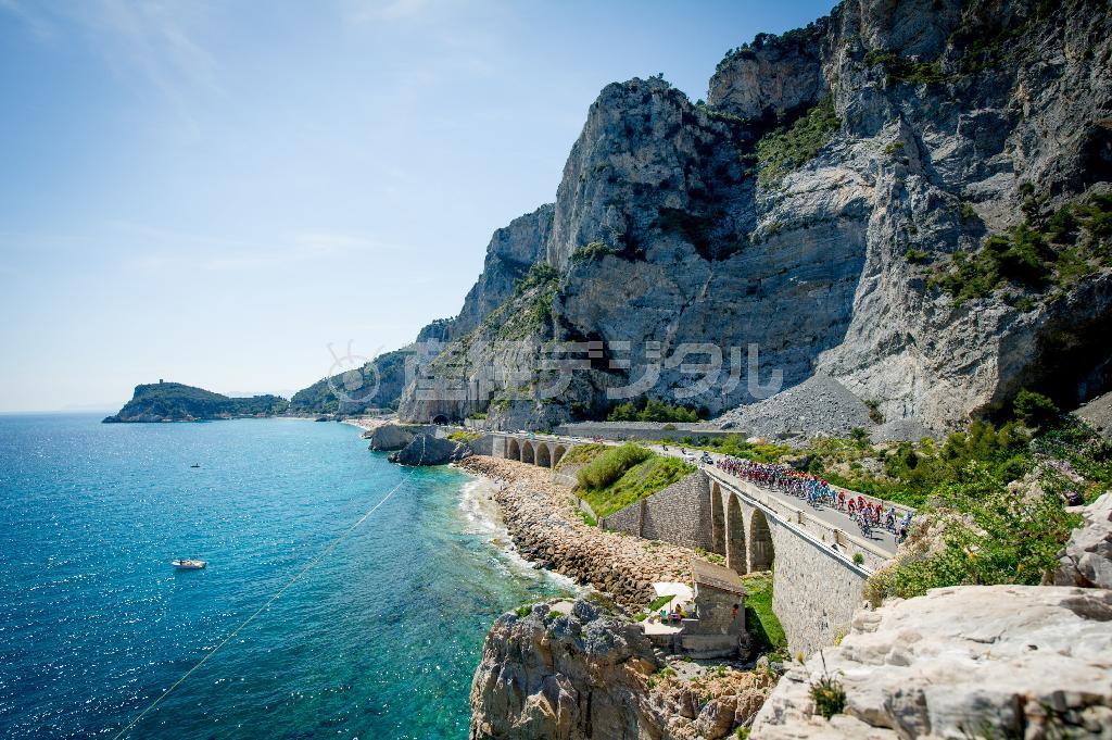 真っ青な海を横目にレースが進んでいく。初夏の陽気で日光浴を楽しむ人たちも＝２０１５年５月１０日、イタリア・リグーリア州（田中苑子さん撮影）