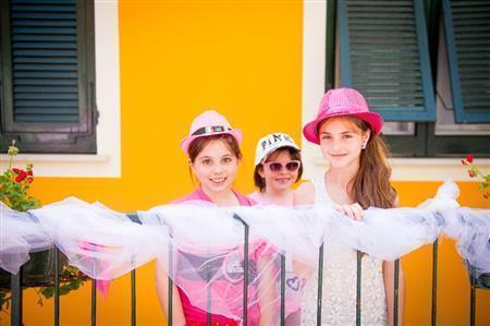 沿道の自宅からレースが通るのを待つ子供たち。レースグッズや持っているピンク色のアイテムを身につけて、選手たちに声援を送る＝２０１５年５月１２日、イタリア（田中苑子さん撮影）