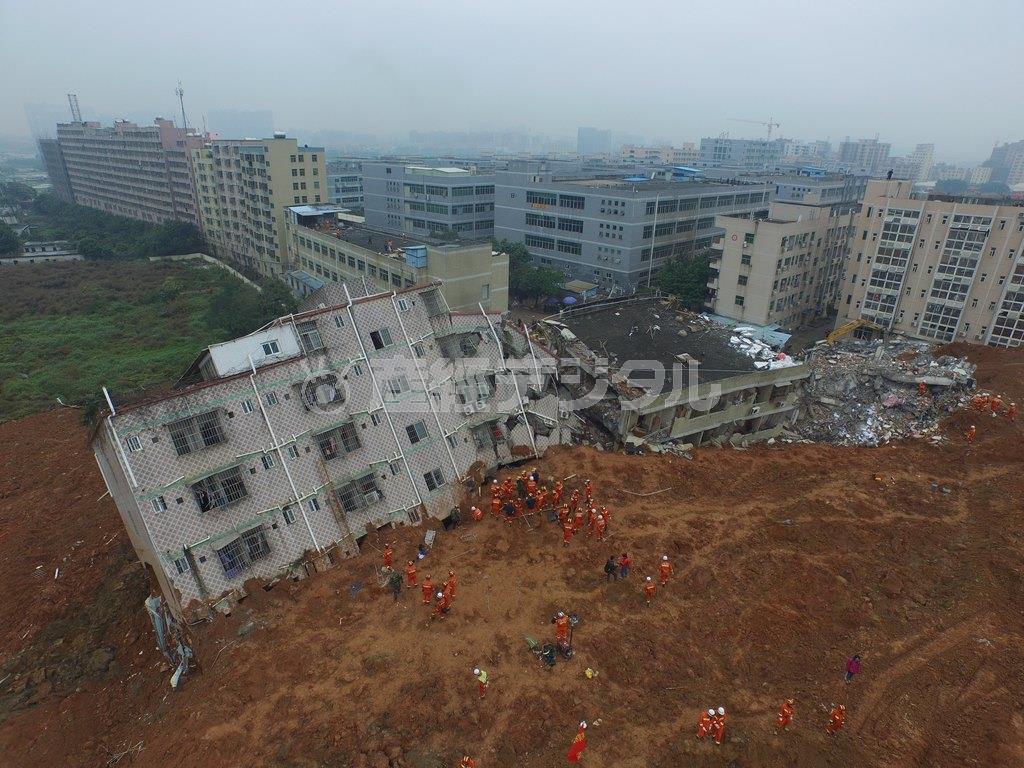 中国・広東省深セン市の工業団地で、土砂崩れにより倒壊した建物を捜索する救助隊員ら＝２０１５年１２月２１日（ロイター）