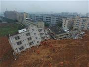 中国・広東省深セン市の工業団地で、土砂崩れにより倒壊した建物を捜索する救助隊員ら＝２０１５年１２月２１日（ロイター）