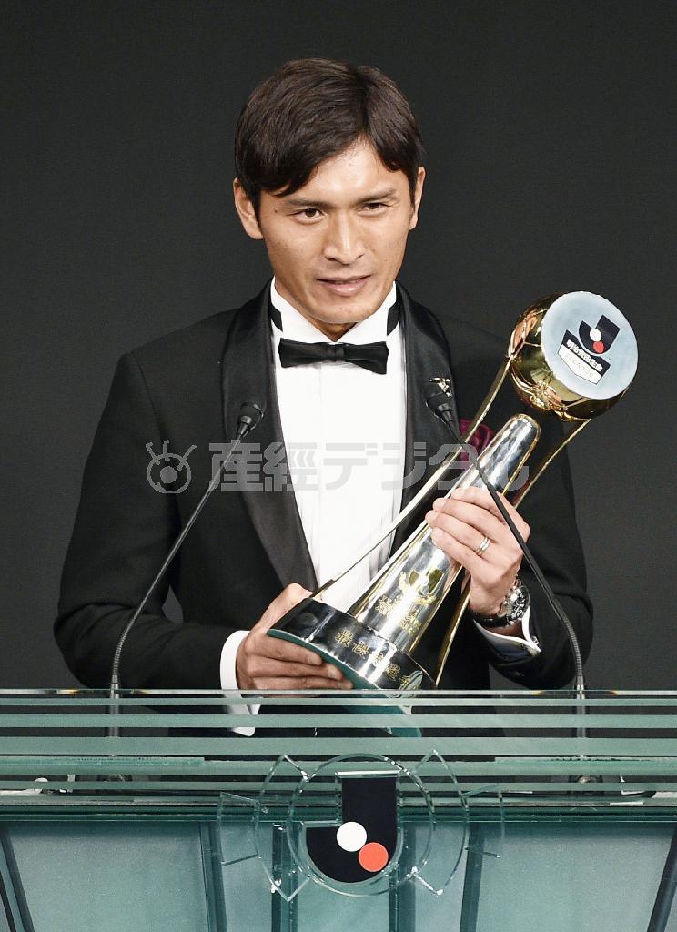 Ｊリーグの年間表彰式で、最優秀選手賞のトロフィーを手にあいさつする広島の青山敏弘＝２０１５年１２月２１日夜、東京都港区のホテル（共同）