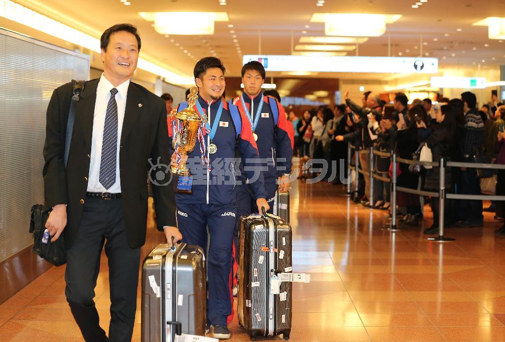 リオデジャネイロ五輪出場を決め帰国した水球男子日本代表の大本洋嗣（おおもと・ようじ）監督（左）と選手たち＝２０１５年１２月２１日、東京都大田区の羽田空港（吉沢良太撮影）