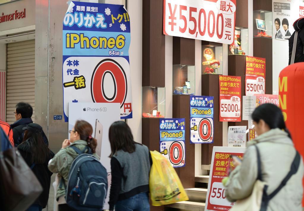 スマートフォン端末「実質０円」や「現金還元」などの表記が目を引く携帯電話の代理店＝２０１５年１２月、大阪市内