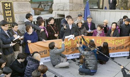 韓国憲法裁判所の決定後、裁判所前で記者会見する原告側の弁護士ら＝２３日、ソウル（共同）