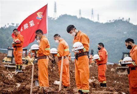 中国・広東省深●（＝土へんに川、しんせん）市の土砂崩れ現場で、犠牲者に黙とうする救助隊員ら＝２０１５年１２月２６日（新華社＝共同）