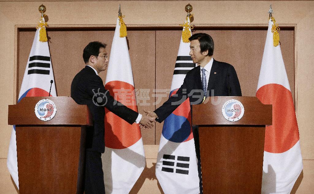 共同記者発表を終え、握手する岸田文雄外相（左）と韓国の尹炳世（ユン・ビョンセ）外相＝２０１５年１２月２８日、韓国・首都ソウルの韓国外務省（ＡＰ）