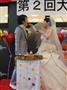 新婦が新郎の口にお好み焼を運ぶファーストバイト＝大阪市城東区