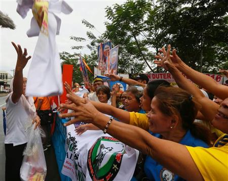 候補者らが無料で配布するＴシャツに殺到する支持者たち。フィリピンは今年５月に行われる大統領選挙による関連支出が経済成長を後押しするとみられている＝マニラ（ＡＰ）