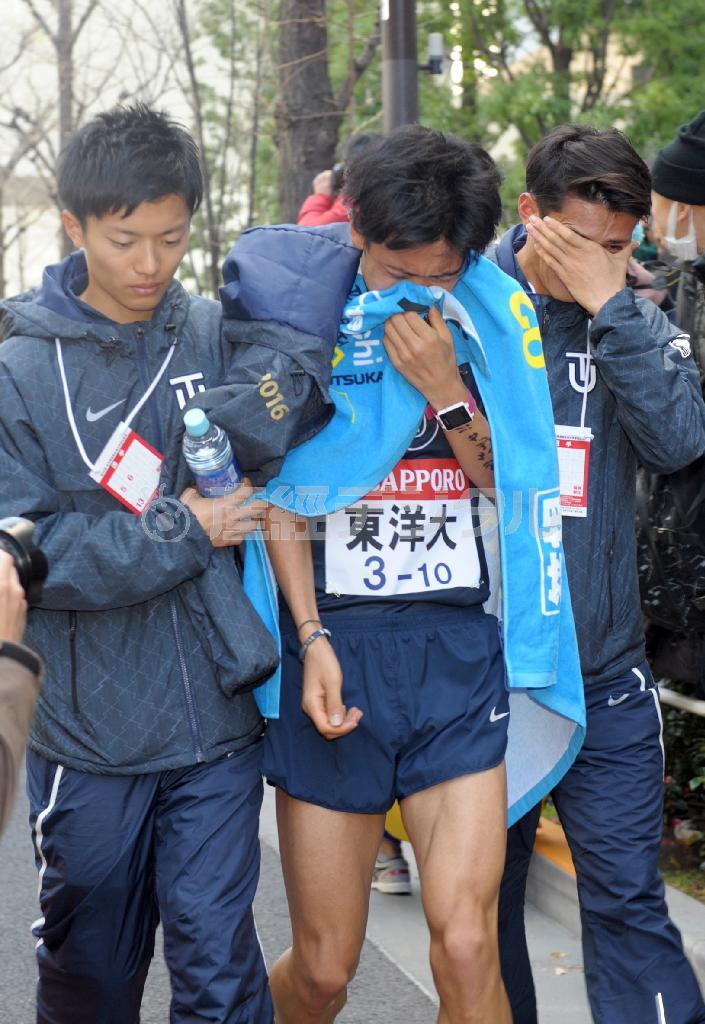 ２位でゴールし、顔をタオルで覆いながら引き上げる東洋大アンカーの渡辺一磨（中央）＝２０１６年１月３日、東京都千代田区大手町（植村光貴撮影）