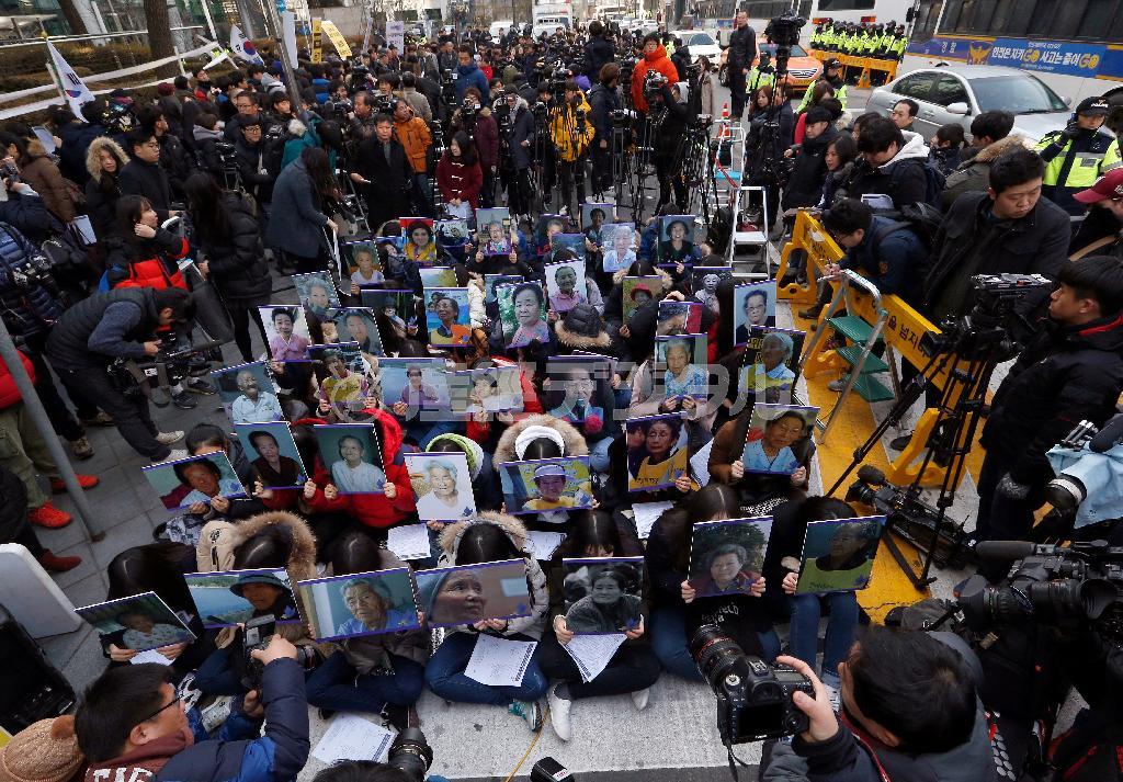 ２０１５年１２月３０日、首都ソウルの日本大使館前で毎週開かれている抗議集会で、元慰安婦たちの遺影を掲げる参加者ら＝韓国（ＡＰ）