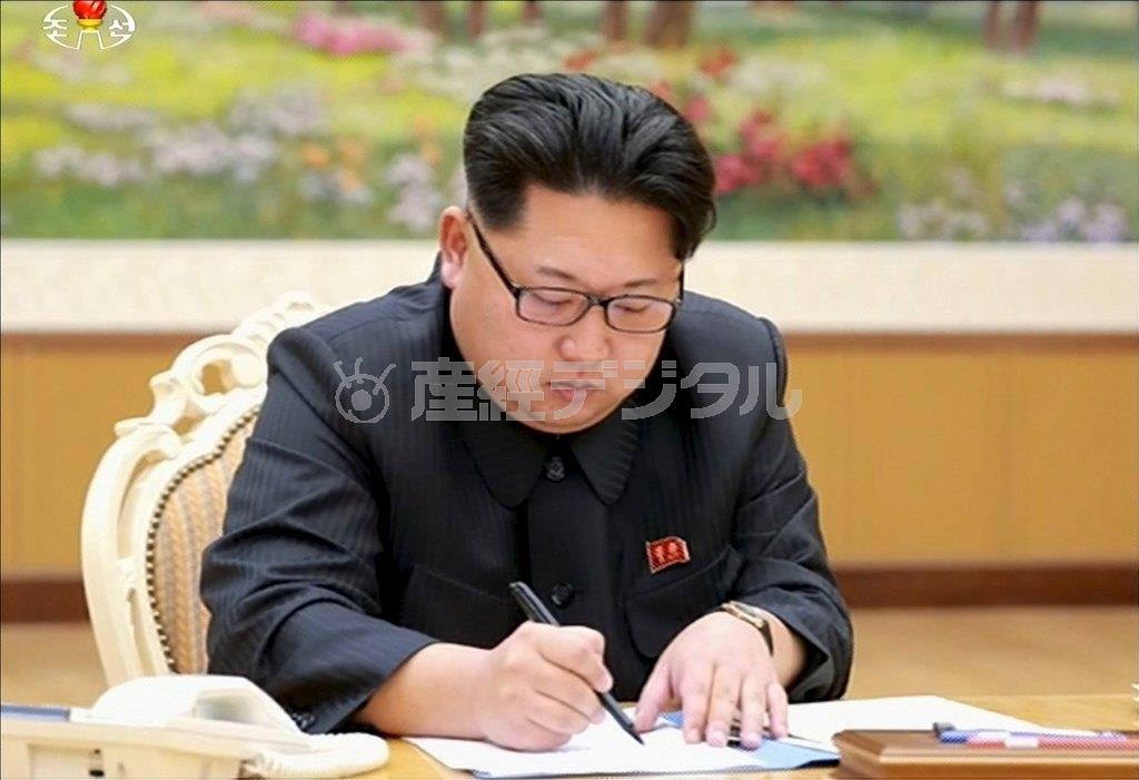 「水爆実験」に関する文書に署名しているとされる金正恩第１書記の写真。朝鮮中央テレビが配信した＝２０１６年１月６日、北朝鮮・首都平壌市（ロイター）