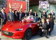 「日本カー・オブ・ザ・イヤー」に選ばれたマツダの「ロードスター」と喜ぶ関係者ら＝２０１５年１２月７日、東京都江東区