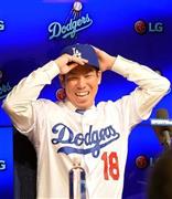 晴れてドジャースの一員となり、入団会見で背番号「１８」のユニホームに袖を通し笑顔を見せる前田健太投手＝２０１６年１月７日、米カリフォルニア州ロサンゼルスのドジャースタジアム（リョウ薮下撮影）