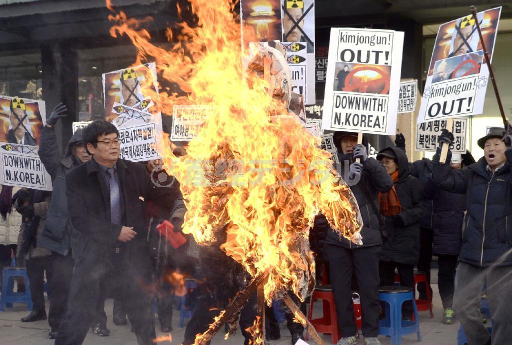 北朝鮮の４回目の核実験に抗議する集会で金正恩（キム・ジョンウン）第１書記の人形を燃やす韓国保守団体のメンバーら＝２０１６年１月７日、韓国・首都ソウル（共同）