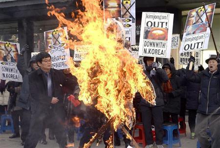北朝鮮の４回目の核実験に抗議する集会で金正恩（キム・ジョンウン）第１書記の人形を燃やす韓国保守団体のメンバーら＝２０１６年１月７日、韓国・首都ソウル（共同）