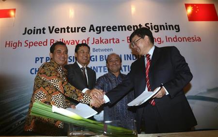 インドネシアの高速鉄道計画の契約について調印し、握手するインドネシアと中国の当局者ら。日本の同国へのインフラ輸出戦略は転換を迫られているが、汚職対策への支援も鍵を握りそうだ＝昨年１０月（ＡＰ）