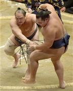 安美錦（あみにしき）が押し出しで鶴竜（かくりゅう）を破る＝２０１６年１月１２日、東京都墨田区の両国国技館（共同）