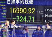 日経平均株価が大幅下落。道行くサラリーマンも足を止めた＝１４日午後、東京・八重洲（伴龍二撮影）