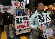 失跡事件への抗議デモを行う香港市民。銅鑼湾（どらわん）書店の株主で、作家でもある李波氏のお面をかぶった参加者も＝２０１６年１月１０日、中国・香港（ＡＰ）