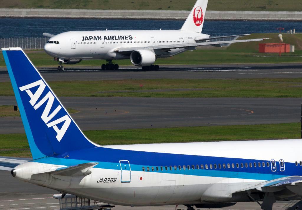 成田空港で離陸を待つ全日本空輸と日本航空の飛行機。燃油サーチャージの負担軽減で、海外旅行がしやすくなる