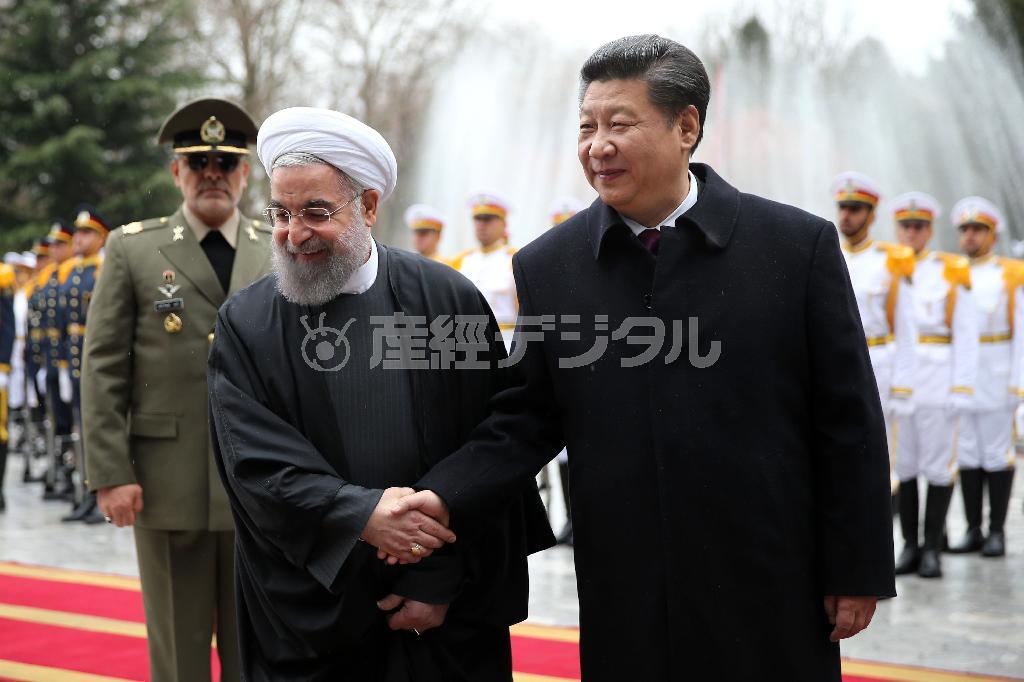 式典でイランのハサン・ロウハニ大統領（左）と握手する中国の習近平国家主席＝２０１６年１月２３日、イラン・首都テヘラン（ＡＰ）