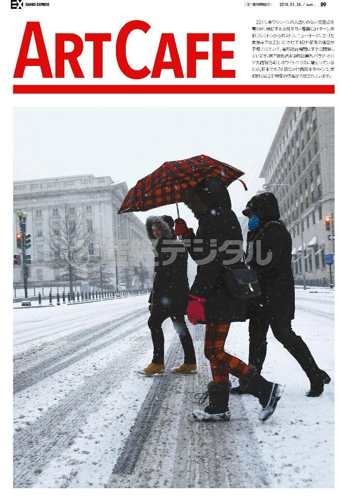 米ワシントンの人通りのない交差点を雪の中、横断する女性たち＝２０１６年１月２２日（ロイター）