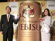 高価格ビール「エビス」をアピールするサッポロビールの尾賀真城社長（左）とイメージガールの柚木渚さん＝東京都渋谷区