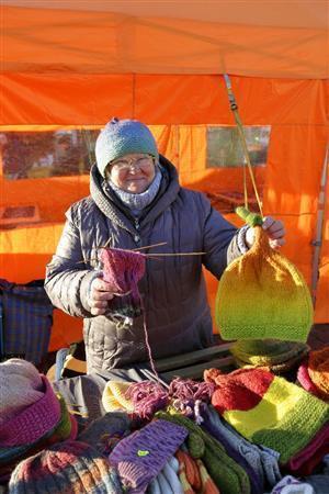 海辺のマーケット広場で「どうですか？」と微笑みかけてくる手作りニット帽を売る女性＝２０１５年１０月９日、フィンランド（倉谷清文さん撮影）