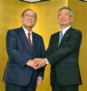 記者会見を終え、握手するキヤノンの御手洗冨士夫会長兼社長最高経営責任者（左）と真栄田雅也専務＝２７日午後、東京都千代田区
