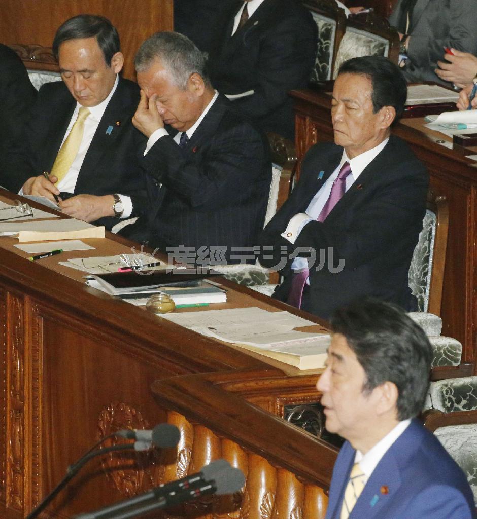 衆院本会議で険しい表情を見せる甘利明（あまり・あきら）経済再生相（奥中央）。手前は答弁する安倍晋三（しんぞう）首相＝２０１６年１月２６日午後（共同）