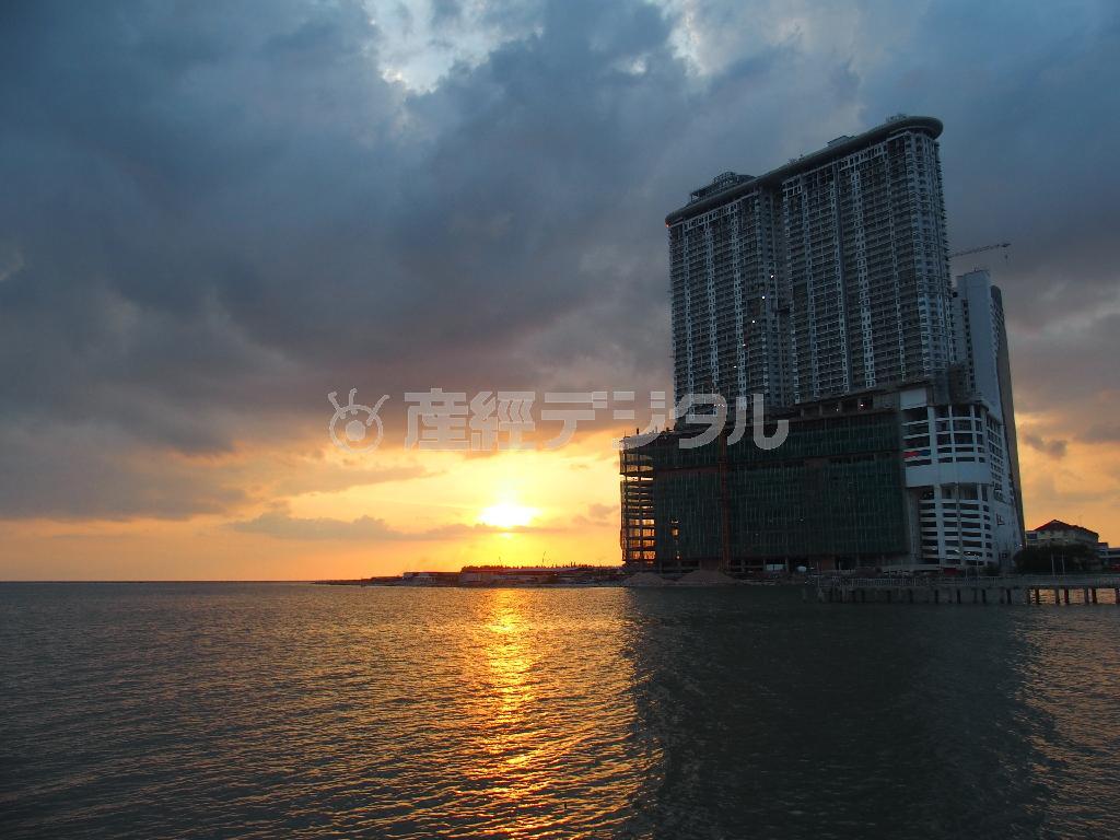 マラッカ海峡に沈む夕日を遮るようにそびえる建設中の中国人目当ての巨大マンション＝２０１６年１月８日、マレーシア・マラッカ（田村秀男撮影）