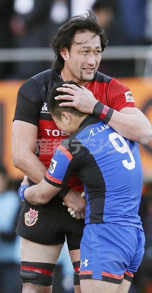 勝って泣く田中史朗（ふみあき）を、敗れた大野均（ひとし）が抱く。大野の左手は田中の頭に、田中の左手は大野の腰に。２人の右手は腹の前で、がっしりと握り合わされていた＝２０１６年１月２４日、東京都港区の秩父宮ラグビー場（共同）