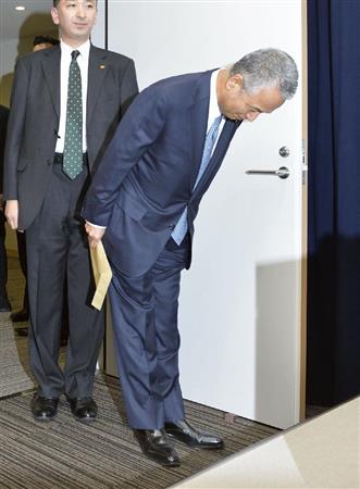 一礼して記者会見場に入る甘利経済再生相＝２８日午後、内閣府