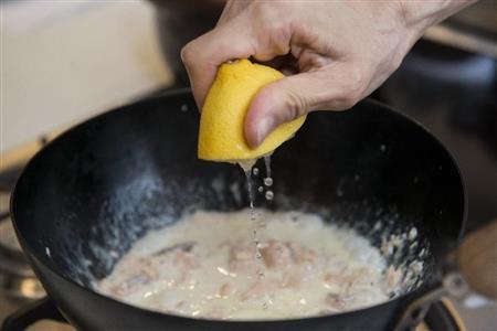鮭と生クリームのパスタソース（作り方）＿＿レモンで味を引き締める（松下二郎さん撮影）