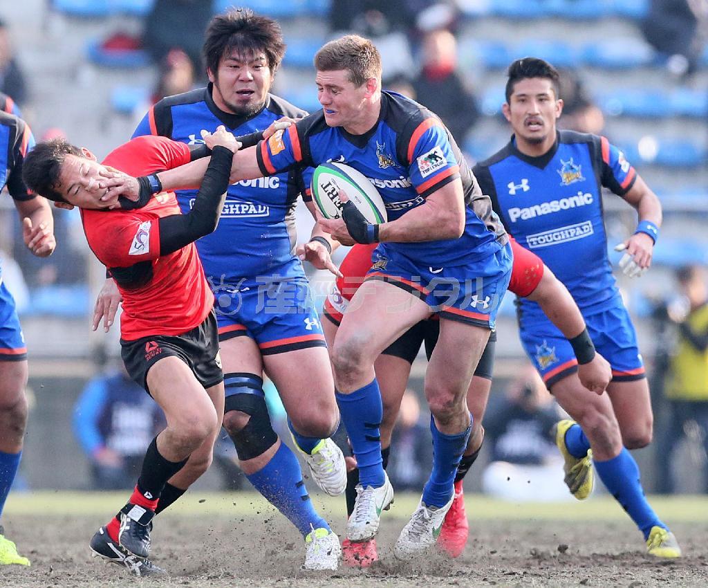 後半、必死にくらいついて突破をはかるパナソニックのベリック・バーンズ（中央）＝２０１６年１月３１日、東京都港区の秩父宮ラグビー場（中井誠撮影）