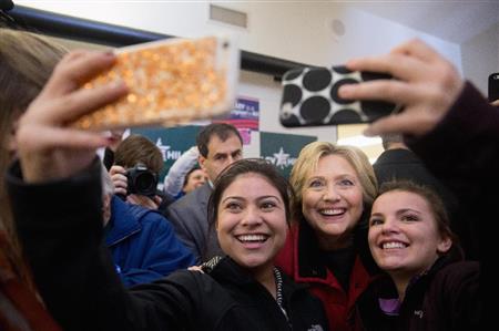 １日、米アイオワ州デモインの選挙事務所でスタッフと写真を撮るクリントン前国務長官（ＡＰ）