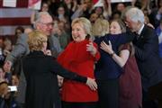 トム・ハーキン元米国上院議員（左）らと抱き合うヒラリー・クリントン氏。予想外の苦戦を強いられた＝２０１６年２月２日、米アイオワ州デイモン市（ロイター）