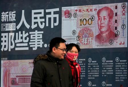新しい百元札のＰＲデザインが描かれた壁の前を歩くカップル。市場では人民元の切り下げ観測が高まっている＝北京市内（ＡＰ）