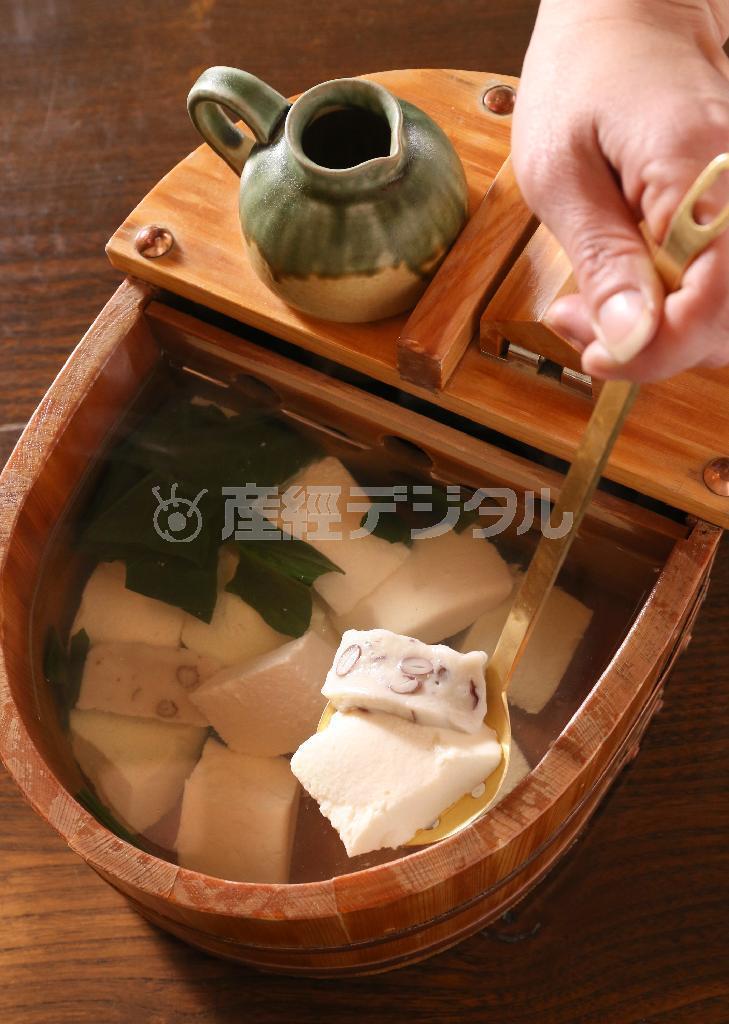 大きな檜の桶にはいった「名物おぼろ湯豆腐」。沸騰しない温度で豆腐を温めるので、豆本来の甘さを損なわない。料理は全て夜の「みやび」コース（５５００円）より＝２０１６年１月２６日、京都市中京区（志儀駒貴撮影）