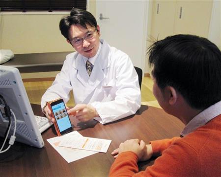 ウェルビーのアプリの使い方を説明する江の島弁天クリニックの松村浩道院長＝神奈川県藤沢市