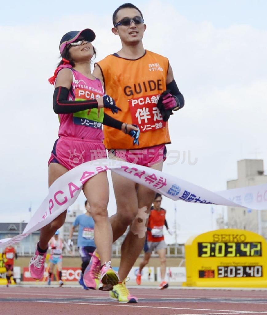 ３時間３分４２秒で視覚障害女子優勝の道下美里（左）＝２０１６年２月７日、大分県大分市の大分市営陸上競技場（共同）