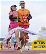 ３時間３分４２秒で視覚障害女子優勝の道下美里（左）＝２０１６年２月７日、大分県大分市の大分市営陸上競技場（共同）