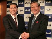 アサヒグループホールディングスの泉谷直木社長（右）と握手する小路明善新社長＝９日、東京都千代田区（松元洋平撮影）