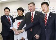 アイスホッケー男子日本代表のグレッグ・トムソン監督（右から２人目）と久慈修平（その左）ら＝２０１６年１月２７日、東京都渋谷区（共同）